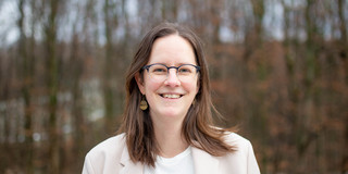 Portraitfoto von Dorothee Gronostay, im Hintergrund: Unscharf abgebildete Vegetation.