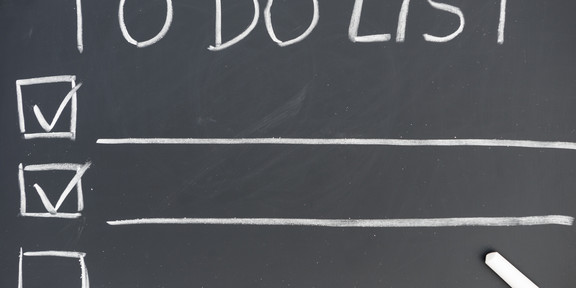 An einer Tafel steht die Überschrift „TO DO LIST”, darunter sind drei Zeilen mit Kästchen an der linken Seite und einem lange Unterstrich. In zwei Kästchen ist ein Haken gesetzt.