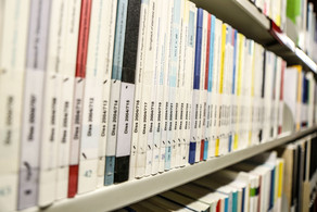 Books with the inscription dissertation on a bookshelf in the library.